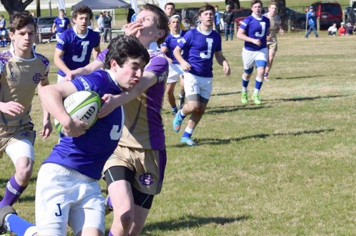 Junior Case Ellis stiff arms a Wave tackler.