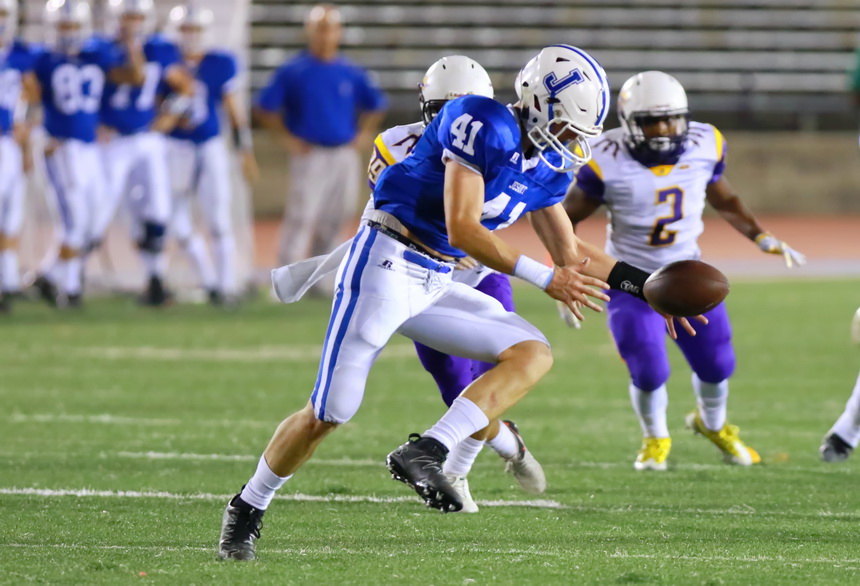 Defensive back Matt McMahon blocks a punt and scoops up the ball in the first quarter of Jesuit's non-district game against Franklinton last Friday night. McMahon ran the blocked punt 29 yards to score Jesuit's third touchdown.