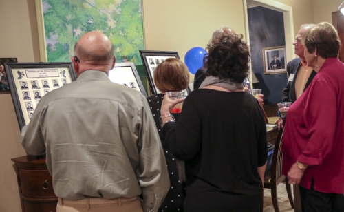 Class members and their guests view photos of deceased classmates.