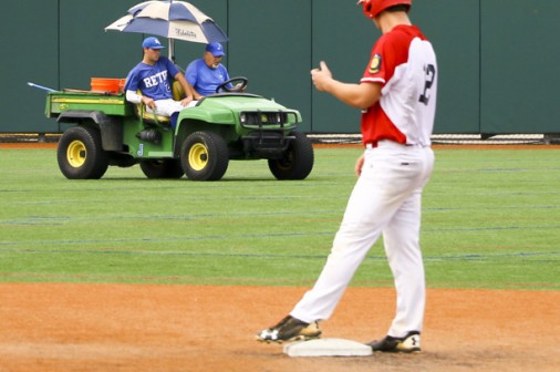 The baserunner glances over at Torry as he is carted off the field by stadium manager and former baseball coach Floyd Guidry.