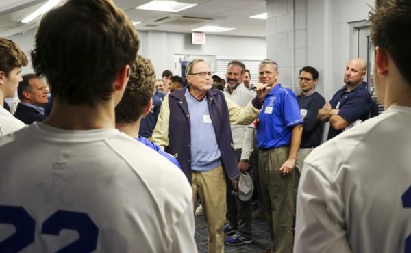 Legendary Blue Jay coach Kevin Trower '52 shows current players a watch inscribed with his state championship years.