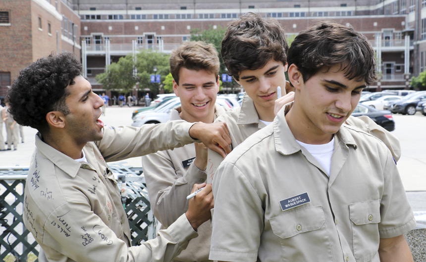 Laith Alkahby, Dylan McKeough, Logan Barrois, and Aubert Waguespack get their uniform shirts signed.
