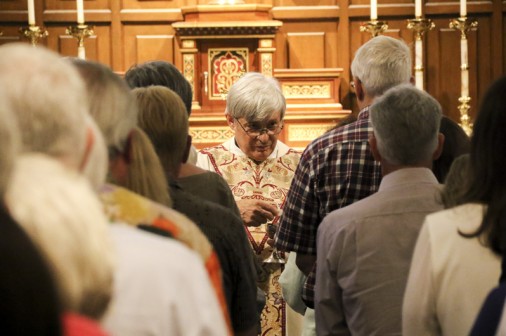 Fr. Eddie Gros, S.J. '68 distributes Communion to Blue Jays and their guests.