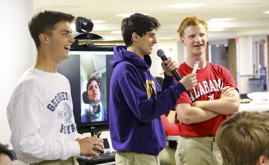 Leo John Arnett, Logan Barrois, and Paul James hand out the "Senior Superlative" awards while classmate, Chris Morelhand, particpiates via Skype.