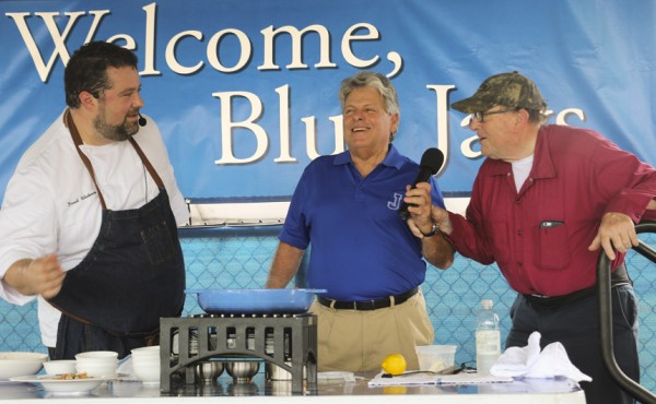 With alumni director Mat Grau encouraging him, Bro. Billy Dardis, S.J., weighs in on the spiciness of the dish prepared by celebrity chef David Whitmore '90.